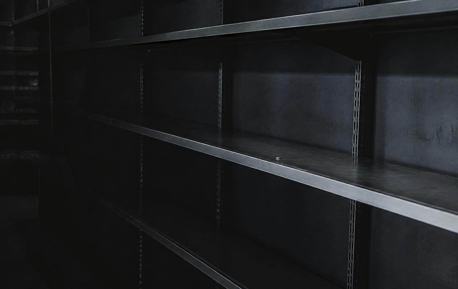 An empty retail shelf in dim light